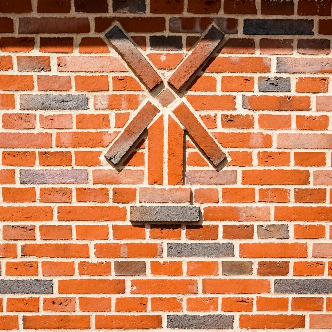 A brick wall with a decorative windmill pattern.